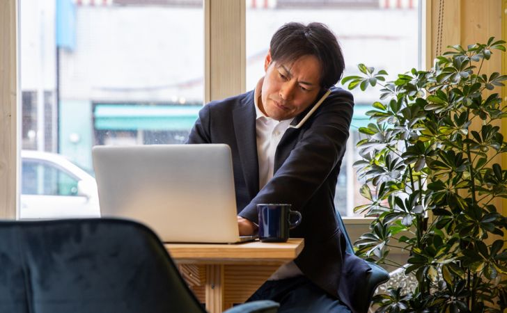 営業電話を迷惑がる会社員男性